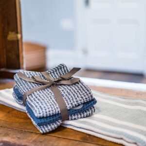 Close-up of rustic linen towels neatly stacked on a wooden surface indoors.