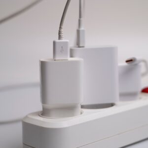 Minimalist composition of electronic device chargers connected to a power strip indoors.