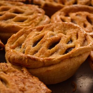 Golden brown apple pies with lattice crusts, capturing the essence of traditional Mexican bakery treats.