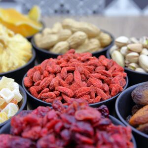 A vibrant collection of dried fruits and nuts in bowls, ideal for nutrition and healthy eating concepts.