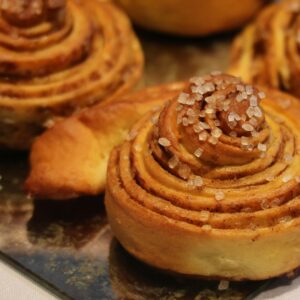 Home Close-up of freshly baked cinnamon rolls topped with sugar crystals, ideal for breakfast or snacks.