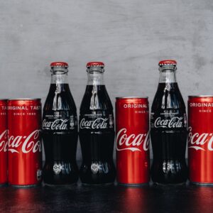 A lineup of Coca Cola bottles and cans representing the classic and refreshing brand image.