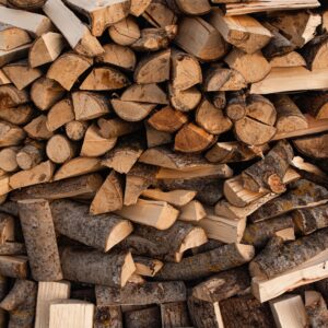 Close-up of a neatly stacked pile of chopped firewood logs, outdoors in natural light.