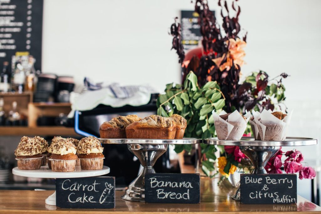 Various many sweet cakes placed on wooden counter for sale in cafe in daytime