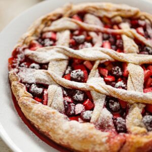 Delicious homemade berry pie with powdered sugar on top, freshly baked for a perfect treat.