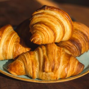 Home Close-up of freshly baked golden croissants on a plate, perfect for breakfast imagery.